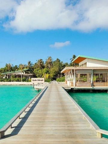 Holzsteg zu Villen über türkisfarbenem Wasser