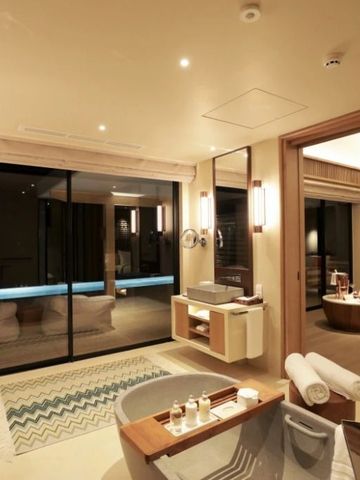 Badezimmer bei Nacht mit direktem Zugang zur Terrasse und moderner Ausstattung