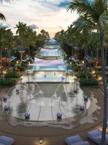 Infinity Pool mit Palmen und Wasserfontänen in tropischer Umgebung