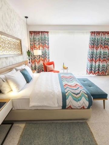 Helles Hotelzimmer mit stilvoller Einrichtung und breitem Bett