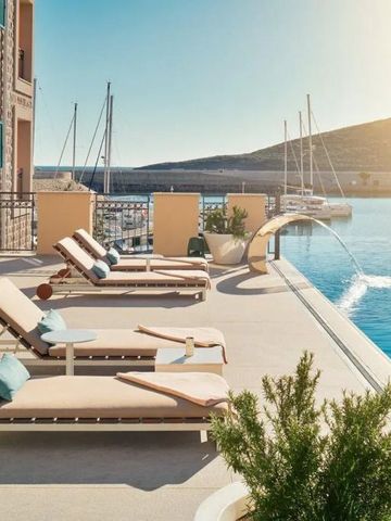 Poolbereich mit Liegen am Wasser und Blick auf den Yachthafen