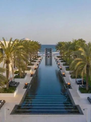 Langer Infinity-Pool mit Palmen und Meerblick