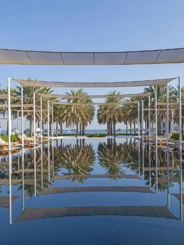 Infinity Pool mit Palmen und Ozeanblick im Hintergrund.