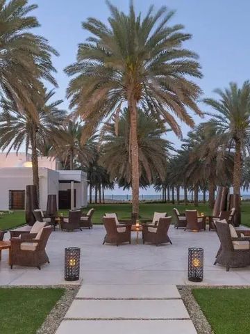 Loungebereich im Freien mit Palmen und Sitzgelegenheiten bei Sonnenuntergang