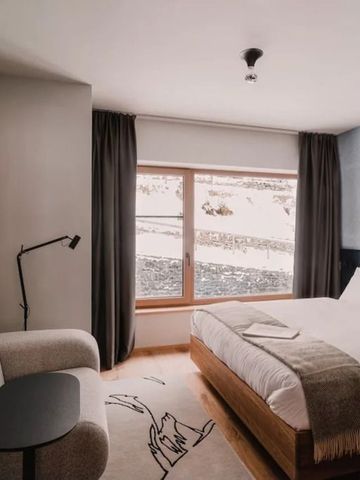 Modernes Hotelzimmer mit gemütlicher Sitzgelegenheit und großem Fenster