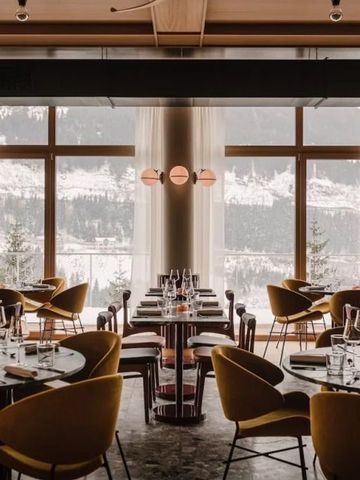 Elegantes Restaurant mit großen Fenstern und Blick auf verschneite Landschaft