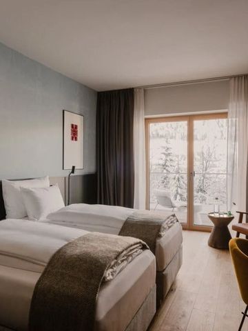 Modernes Hotelzimmer mit zwei Betten und großem Fenster mit Bergblick