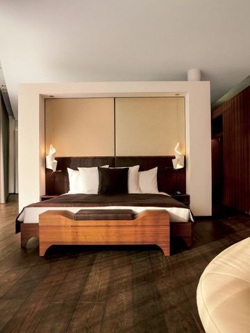 Elegantes Zimmer mit edlem Holzboden und moderner Beleuchtung