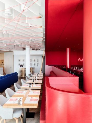 Modernes Restaurant mit roten Wänden und stilvoller Einrichtung