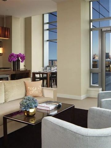 Modern eingerichtetes Wohnzimmer mit großen Fenstern und eleganten Möbeln.