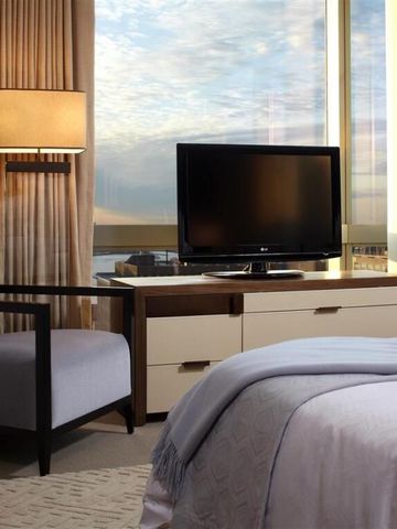 Gemütliches Schlafzimmer mit großem Fenster und weichen Textilien.