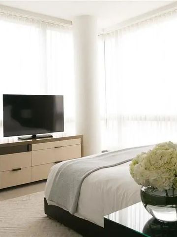 Helles Schlafzimmer mit modernen Möbeln und großen Fenstern.