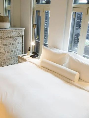 Elegantes Zimmer mit großem Bett und Blick auf historische Fenster