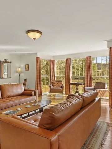 Helles Wohnzimmer mit Ledersofas und großem Fenster