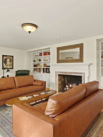 Eleganter Wohnbereich mit Kamin und Ledersofas in einem Hotelzimmer.