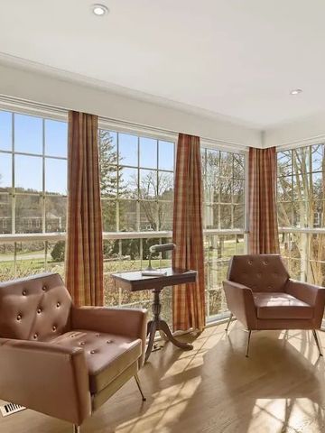 Helle Leseecke mit großen Fenstern und stilvollen Sesseln im Hotelzimmer.