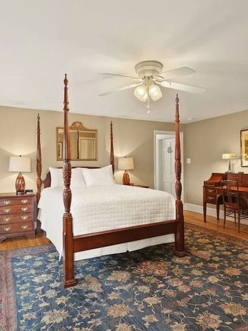 Luxuriöses Schlafzimmer mit Himmelbett und eleganten Holzmöbeln.