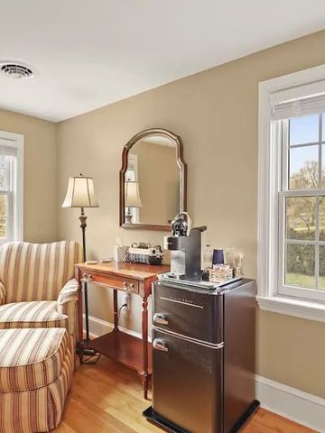 Gemütliche Sitzecke mit Sessel und Kaffeemaschine im Gästezimmer