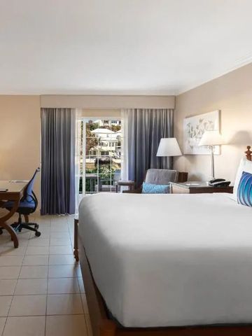 Helles Hotelzimmer mit Balkonblick und modernem Arbeitsbereich