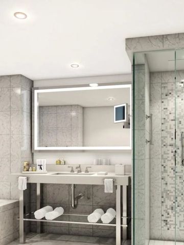 Modernes Badezimmer mit Glasdusche und Spiegelbeleuchtung