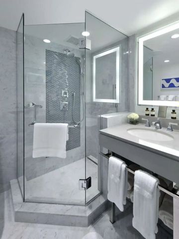 Stilvolles Badezimmer mit gläserner Duschkabine und Marmoroberflächen