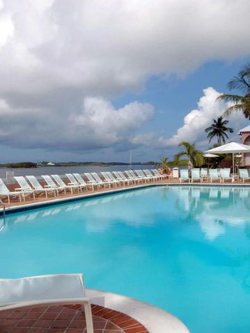 Außenpool mit Liegestühlen und Palmen am Hotelgelände