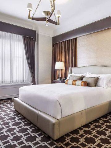 Modern eingerichtetes Schlafzimmer mit luxuriösen Textilien und eleganter Beleuchtung.