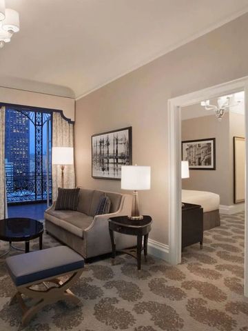 Elegante Suite mit Wohnzimmer, stilvollen Möbeln und Blick auf die Stadt.