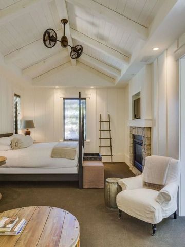 Gemütliches Zimmer mit hohen Decken, Kamin und offener Tür zur Terrasse