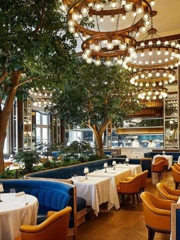 Restaurant mit eleganter Beleuchtung und grüner Einrichtung.