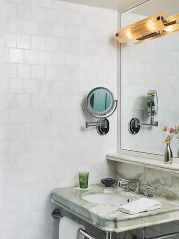 Modernes Badezimmer mit weißem Fliesendesign und eleganten Armaturen.