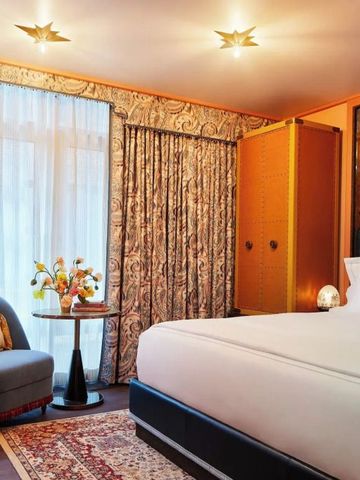 Elegantes Hotelzimmer mit großem Bett, stilvoller Einrichtung und natürlichem Licht.