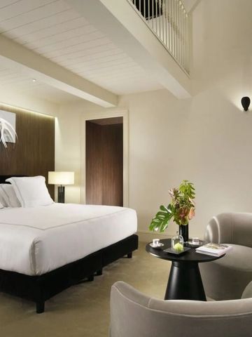 Modernes Hotelzimmer mit Doppelbett, hellem Interieur und gemütlicher Sitzecke.