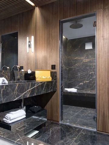 Modernes Badezimmer mit Holzverkleidung und luxuriösem Marmorwaschtisch.
