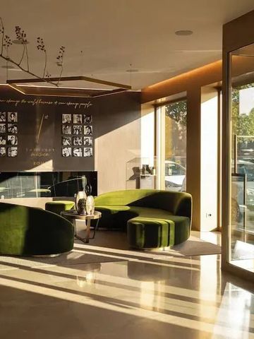 Heller Lobbybereich mit grünen Sofas und großem Fenster zur Straße