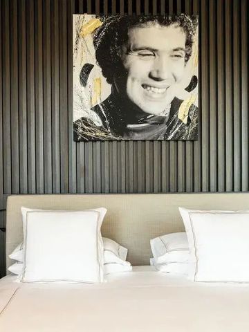 Elegantes Hotelzimmer mit großem Bett und modernem Kunstwerk an der Wand