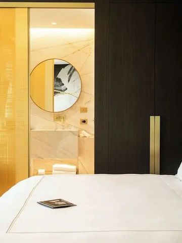 Gemütliches Zimmer mit Doppelbett und Blick ins Bad mit Spiegel