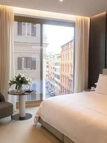 Zimmer mit großem Fenster und Blick auf Stadtgebäude