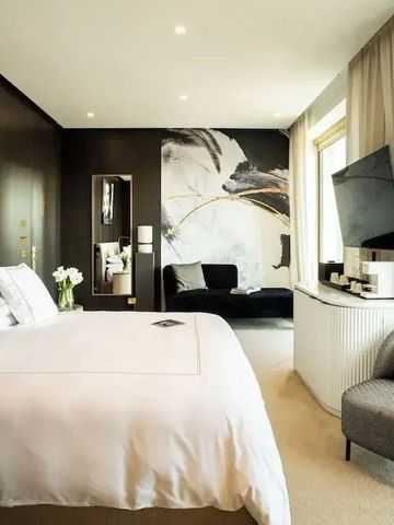 Helles, modernes Zimmer mit großen Fenstern und stilvoller Kunst an den Wänden