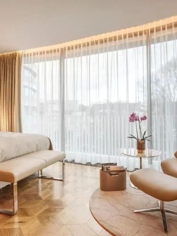 Helles Gästezimmer mit großen Fenstern und eleganten Möbeln