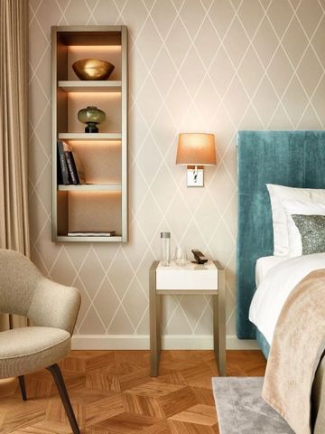 Detailansicht eines stilvollen Hotelzimmers mit Nachttisch und Wandregal