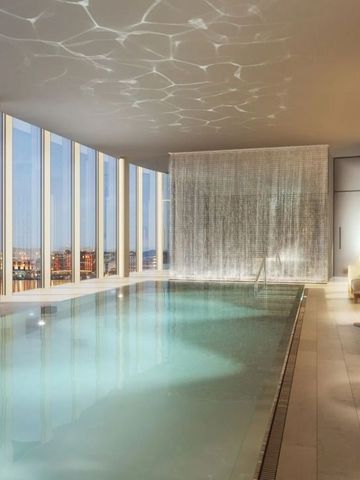 Infinity-Pool mit Blick auf die Stadt, umgeben von eleganten Sitzgelegenheiten