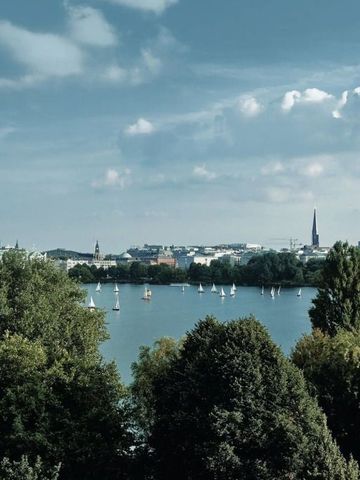 Panoramablick auf einen See mit Segelbooten und üppiger Vegetation