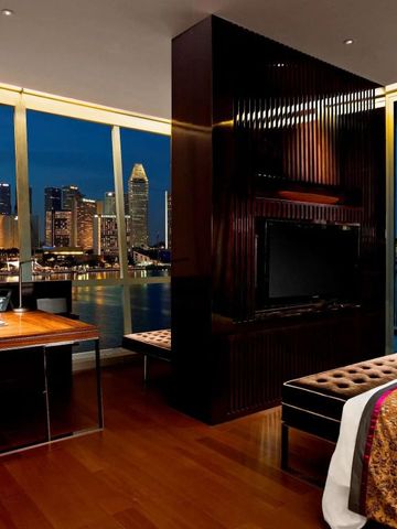 Luxuriöses Hotelzimmer mit Panoramablick auf die Skyline von Singapur bei Nacht