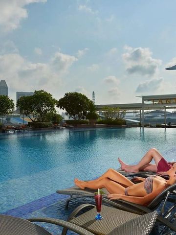 Entspannte Gäste am Pool mit Blick auf die Skyline von Singapur