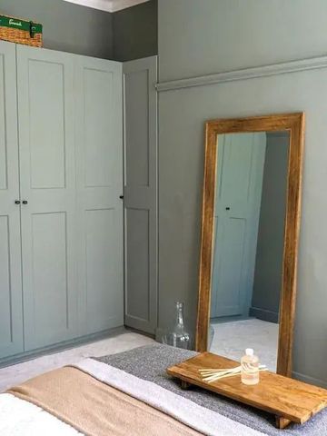 Schlafzimmer mit großem Spiegel und eingebauten Schränken