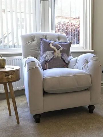 Gemütlicher Sessel mit dekorativem Kissen in ruhigem Raum