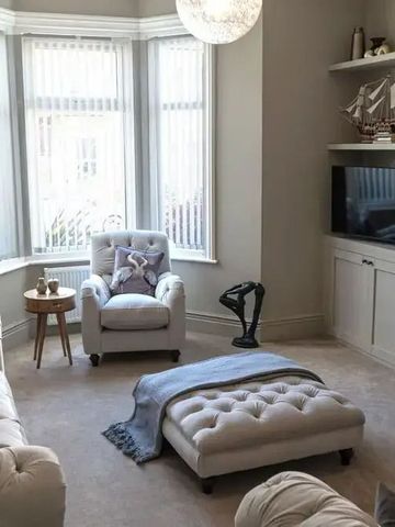 Elegantes Wohnzimmer mit großen Fenstern und stilvollen Möbeln