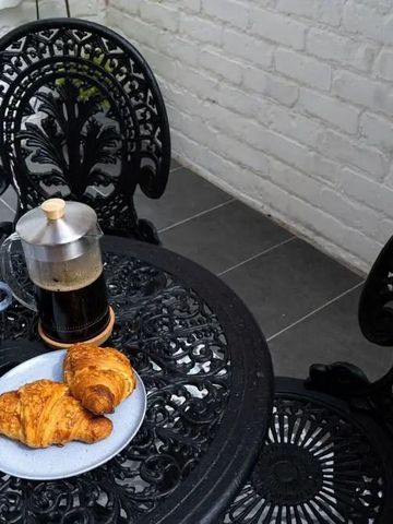 Gemütliche Terrasse mit Tisch, Stühlen, Kaffee und Croissants