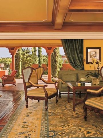 Opulenter Loungebereich mit klassischen Möbeln und Zugang zur Terrasse im mediterranen Stil